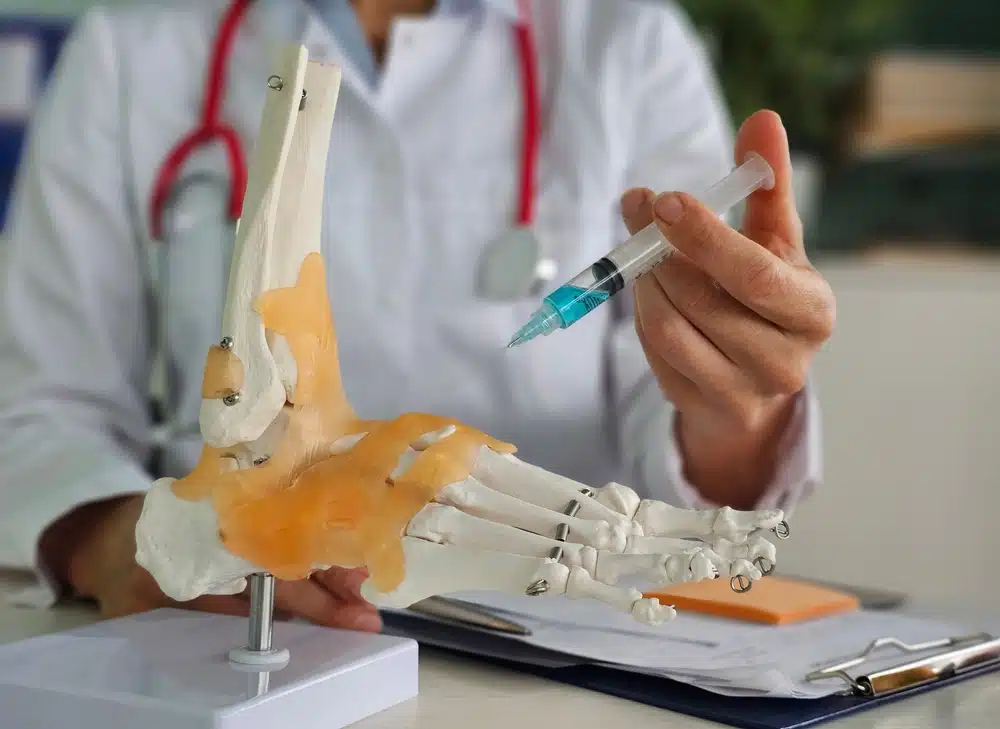 Doctor orthopedist makes an injection with blockade medication